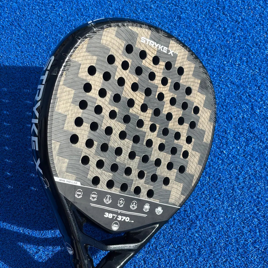 Padelschläger in Tropfenform auf blauem Padelcourt